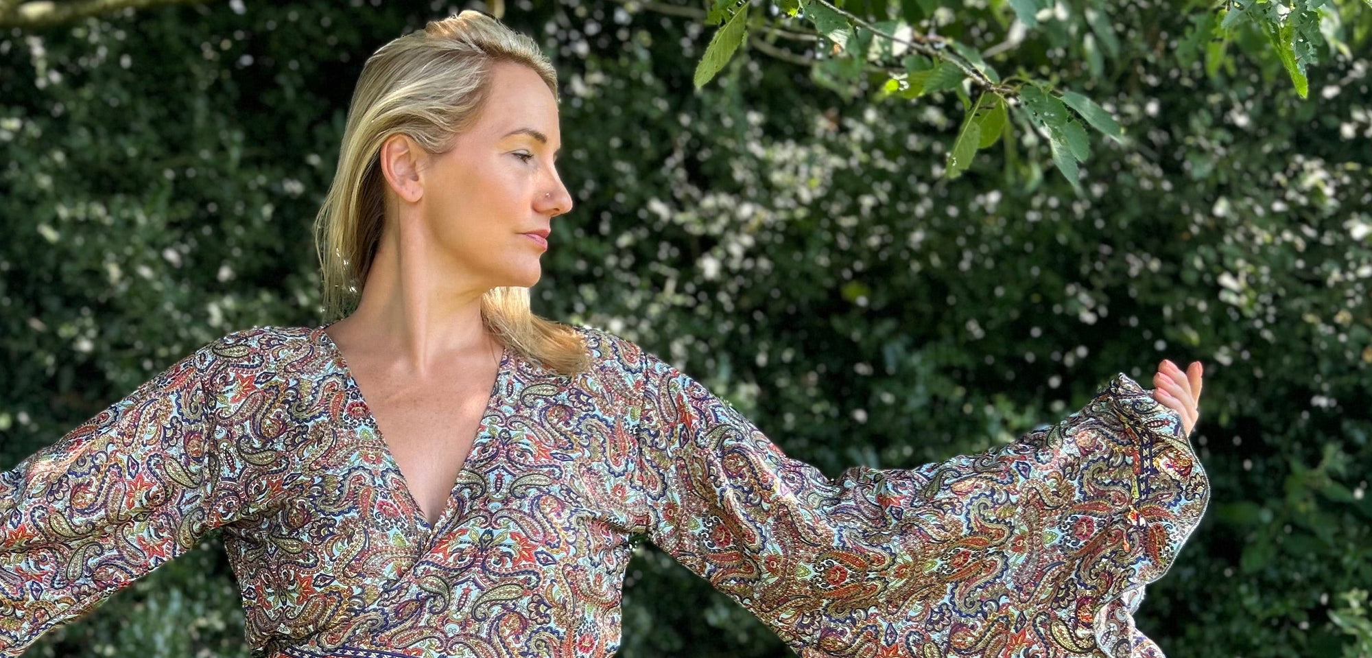 Hippie woman with her arms outstretched wearing hippie wrap top